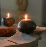 دو عدد شمع سنگی رو شن روی میز چوبی